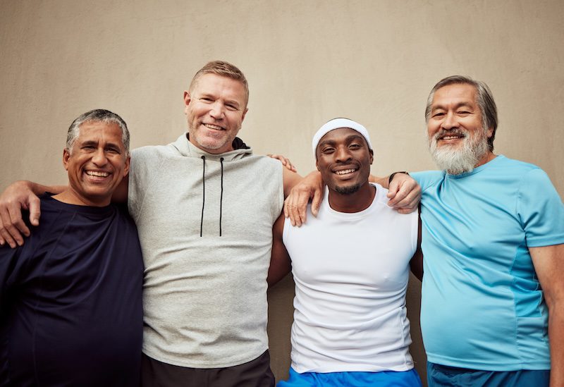 Happy men, exercise group and portrait in city on wall background outdoor. Smile, fitness and matur