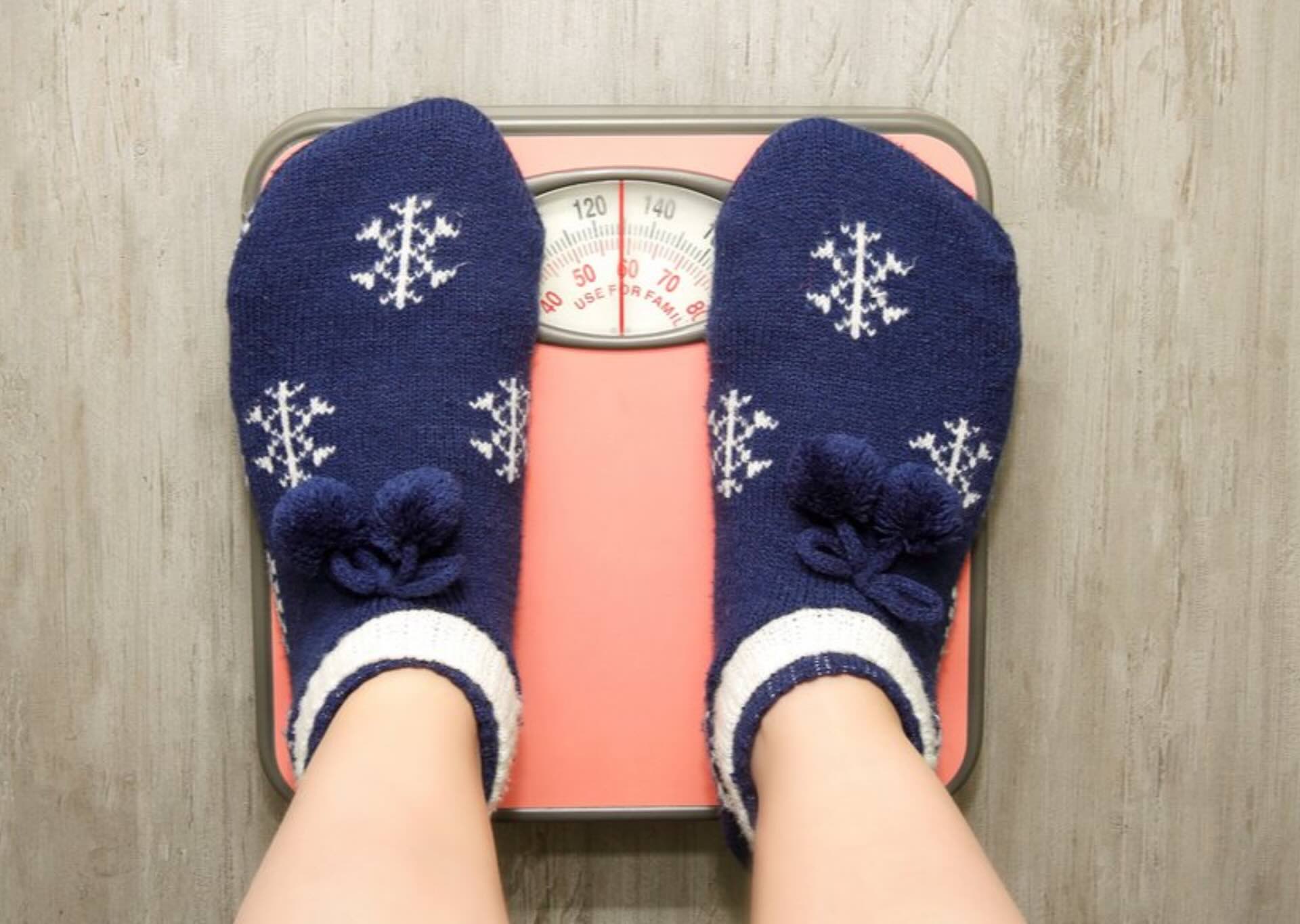 Person wearing winter socks standing on a scale during the holiday season