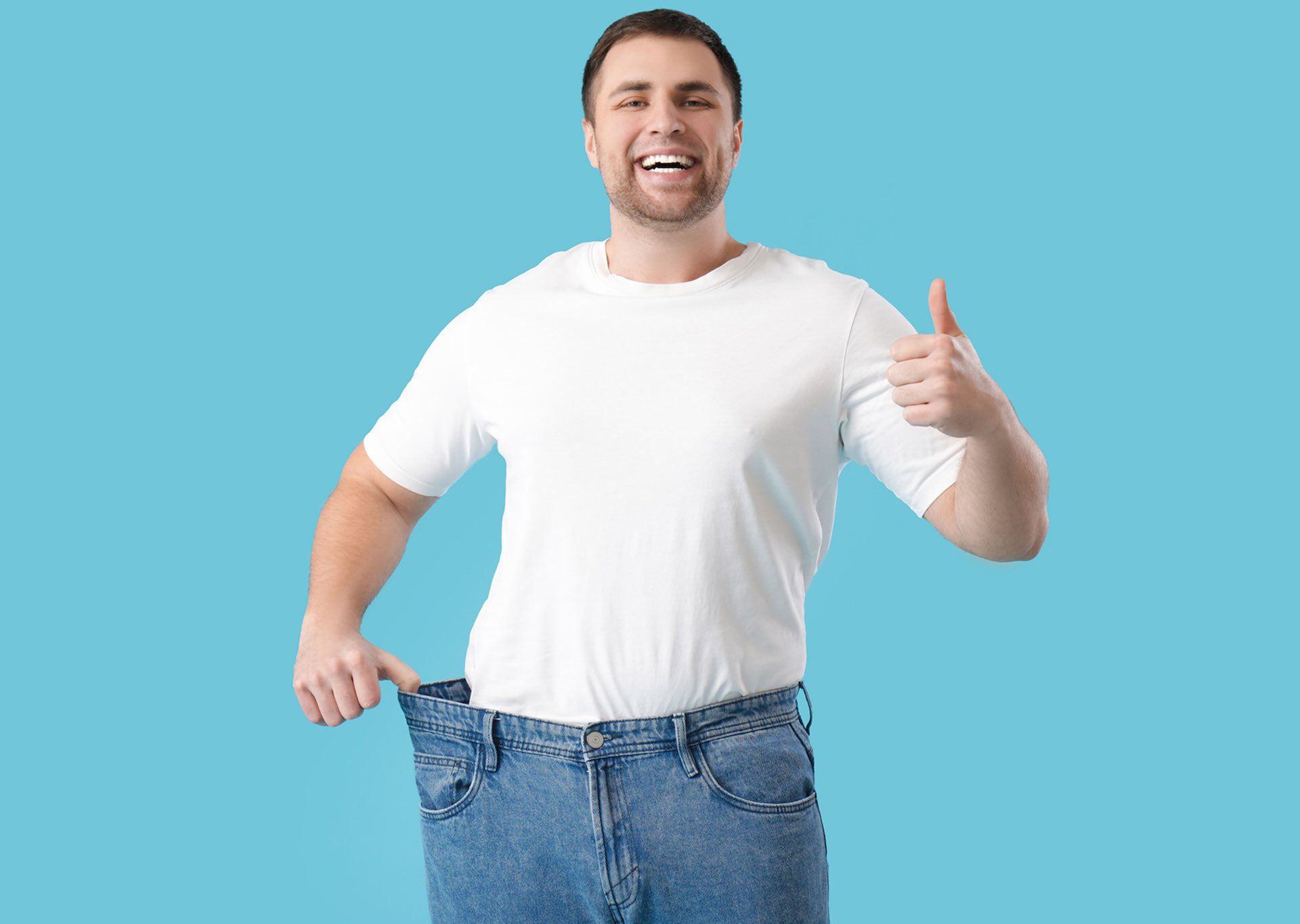 Balanced Hormone Health – December 2025 Blog Images – Semaglutide-and-Lifestyle-The-Most-Powerful-Weight-Loss-Duo Smiling man showing weight loss by wearing oversized jeans