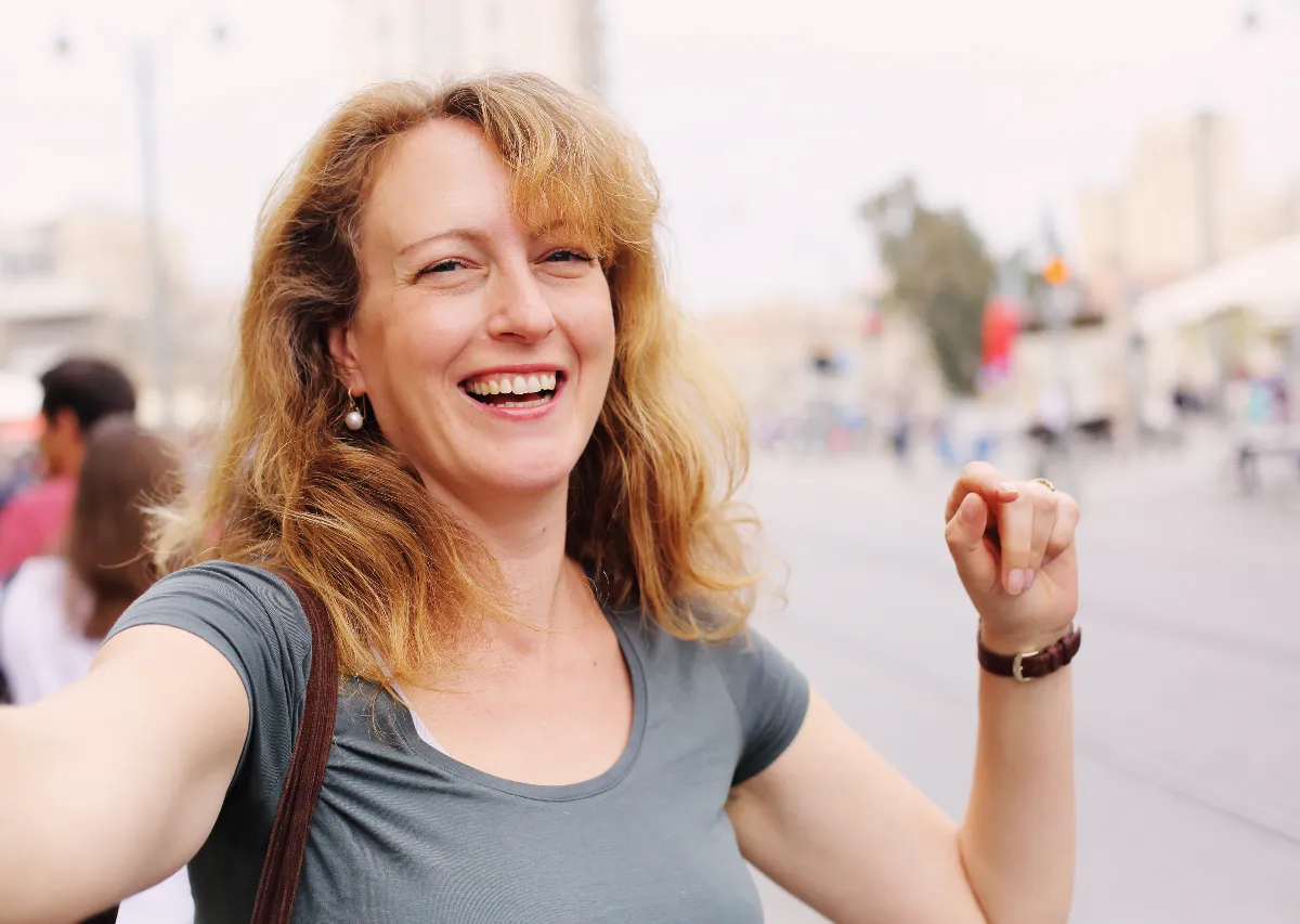 Woman smiling outdoors representing improved energy and hormonal balance through better blood sugar control.