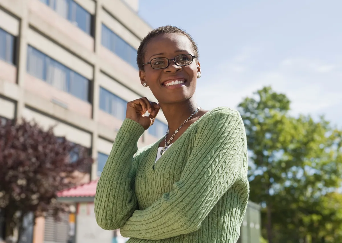 woman outside smiling in front of a building